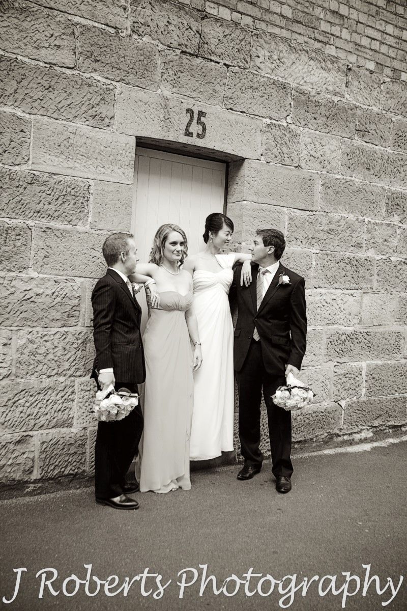Bridal party being silly in front of doorway the rocks sydney - wedding photography sydney